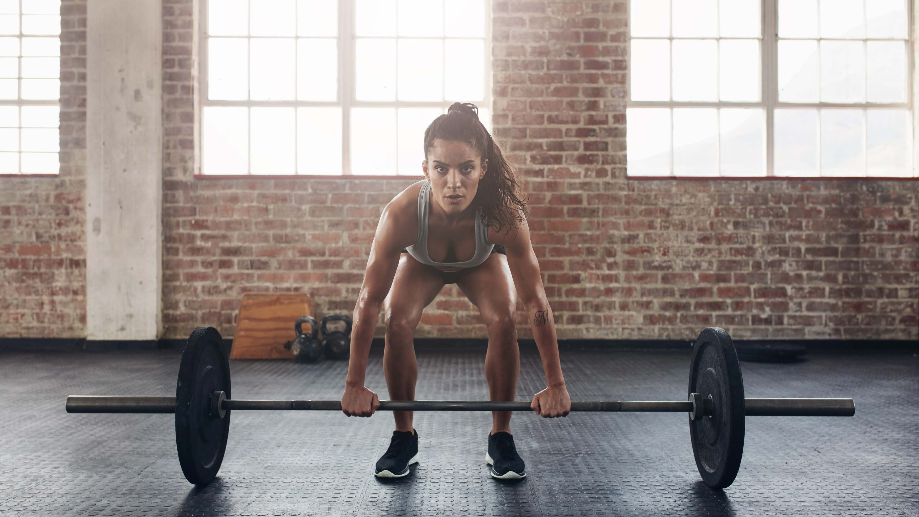 Eine Sportlerin beim Langhanteltraining
