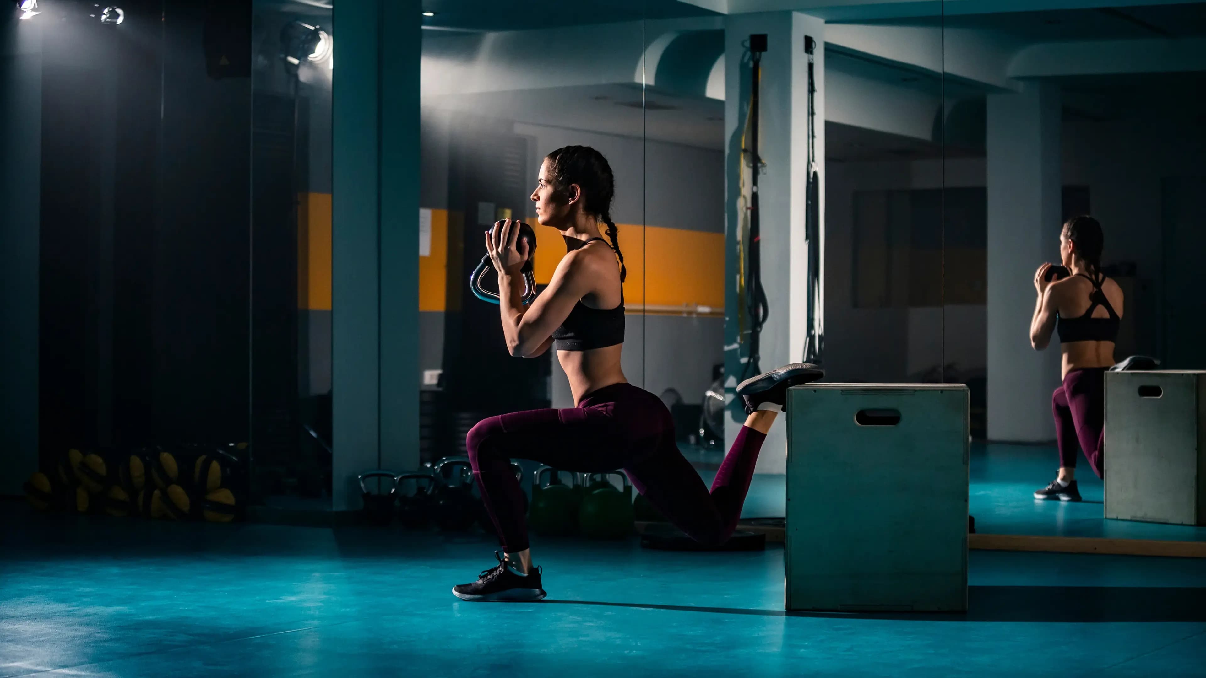 Frau macht BULGARIAN SPLIT SQUAT mit Kettleball