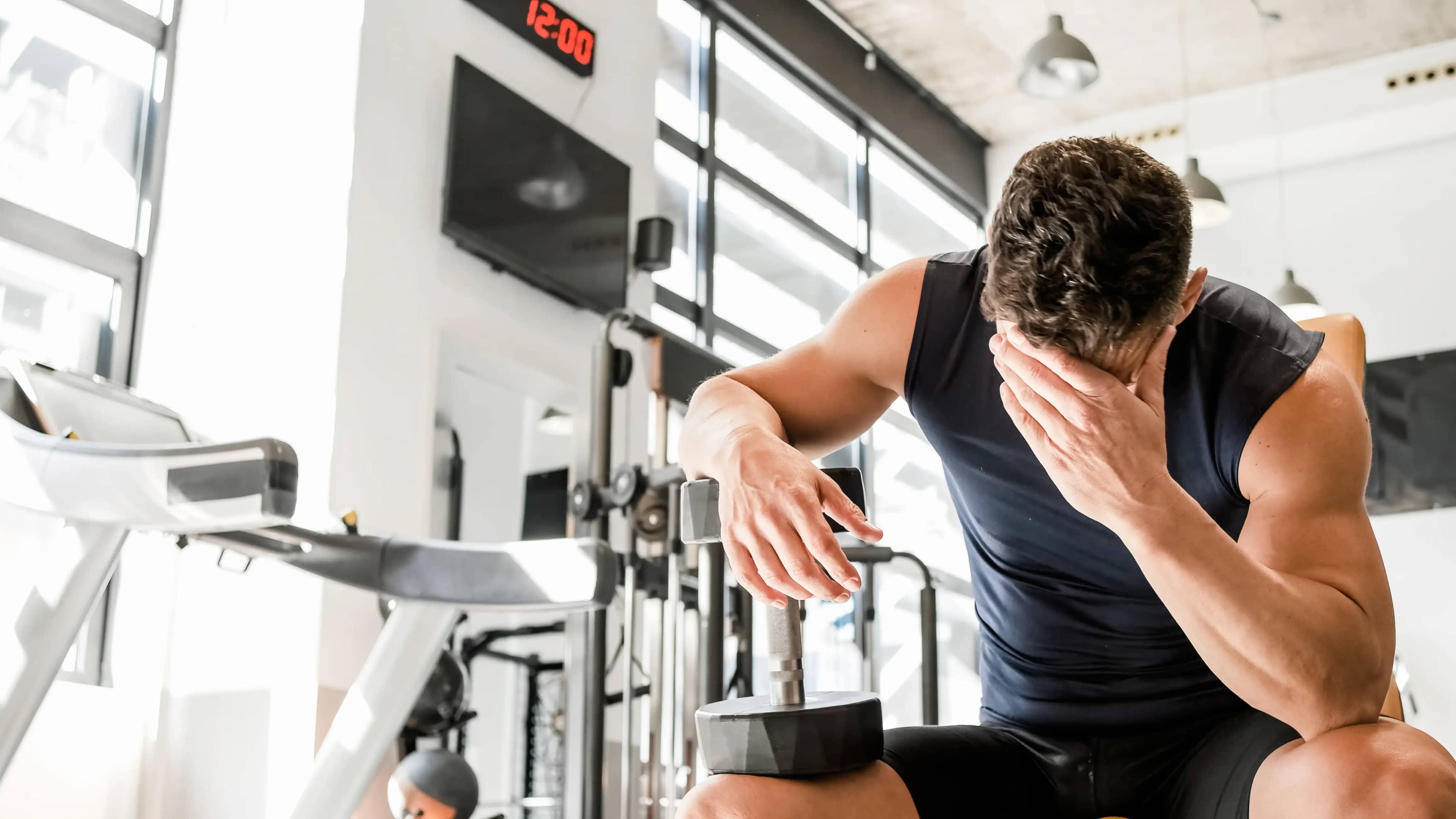 Ein Mann fasst sich nach Anstrengung beim Sport an die Stirn
