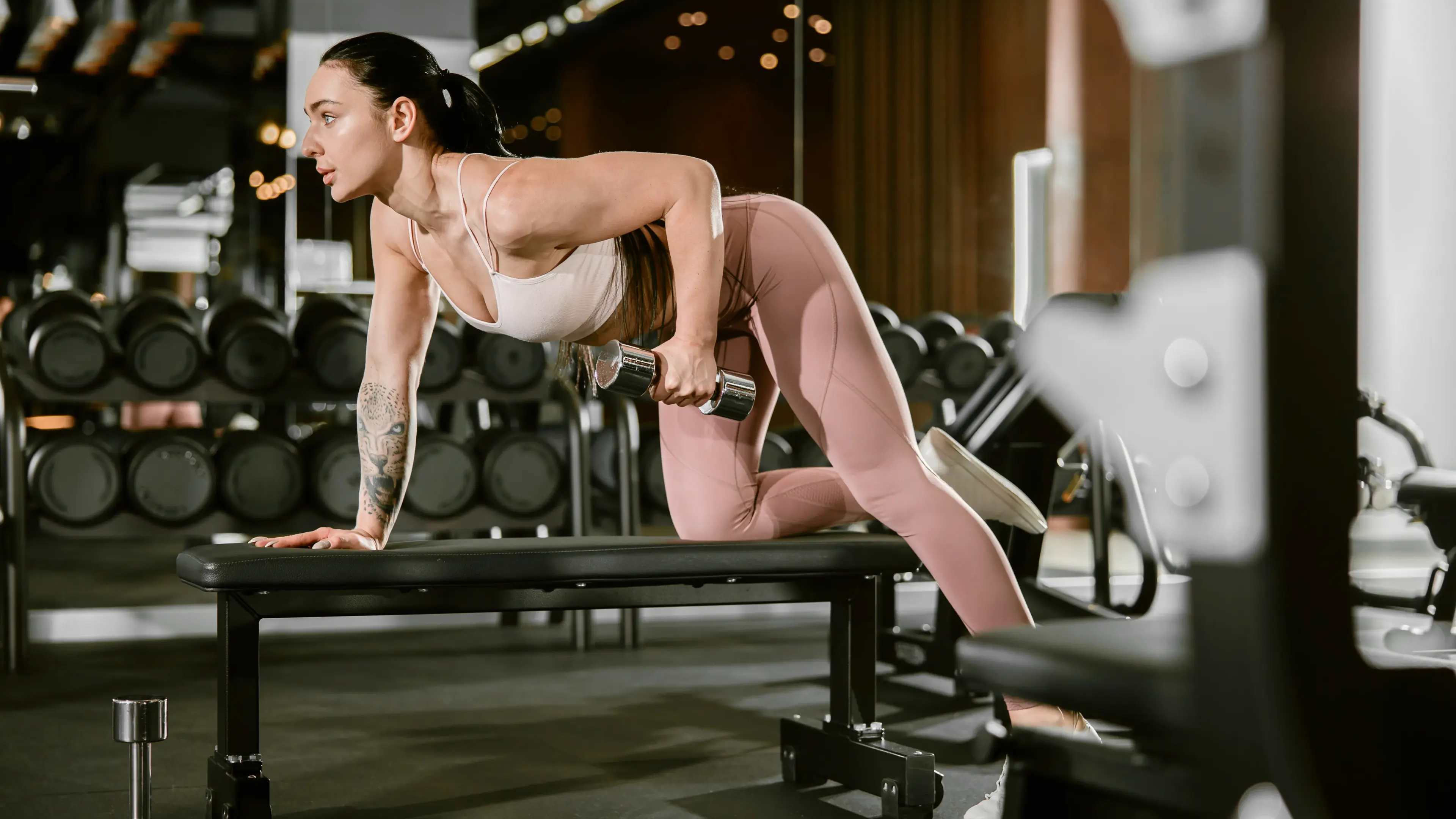Eine Frau beim Kurzhantel-Rudern im Fitnessstudio