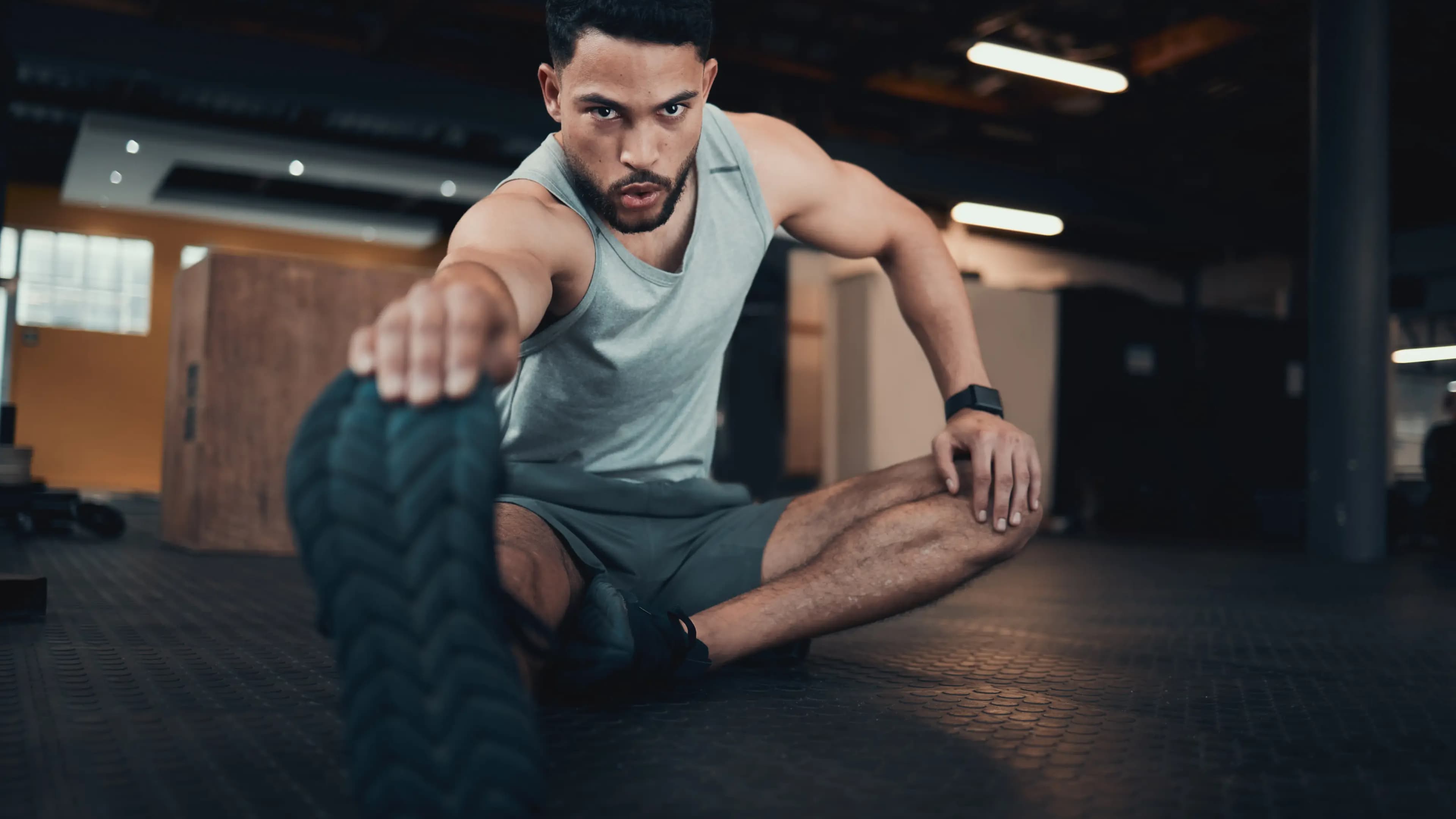 Ein Mann dehnt sich im Fitnessstudio