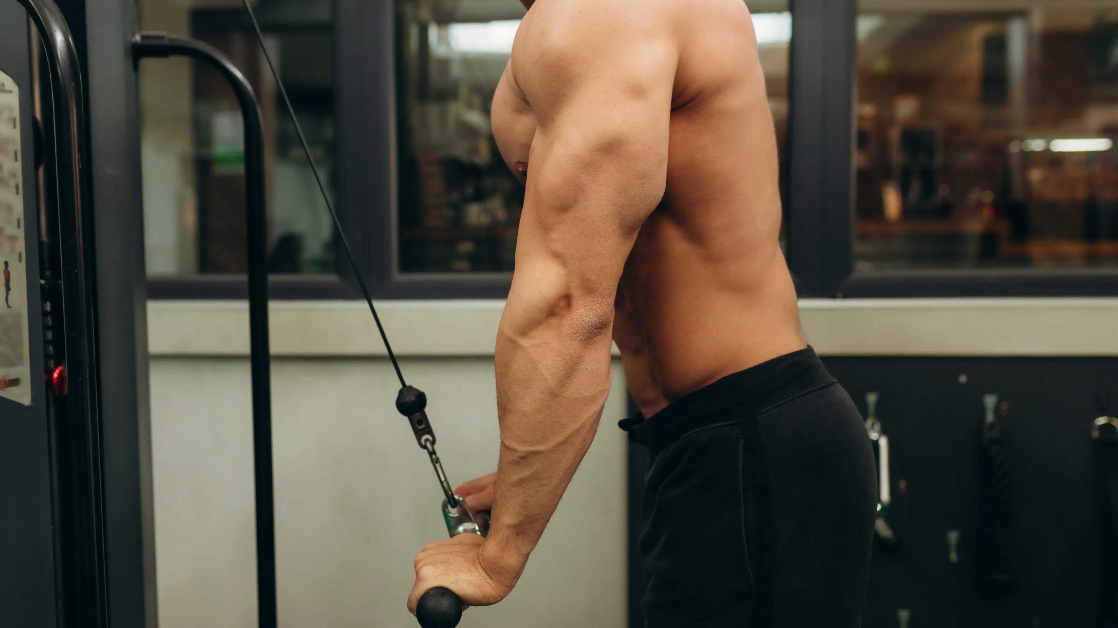 Ein Mann macht Tricep Pushdowns am Kabelzug
