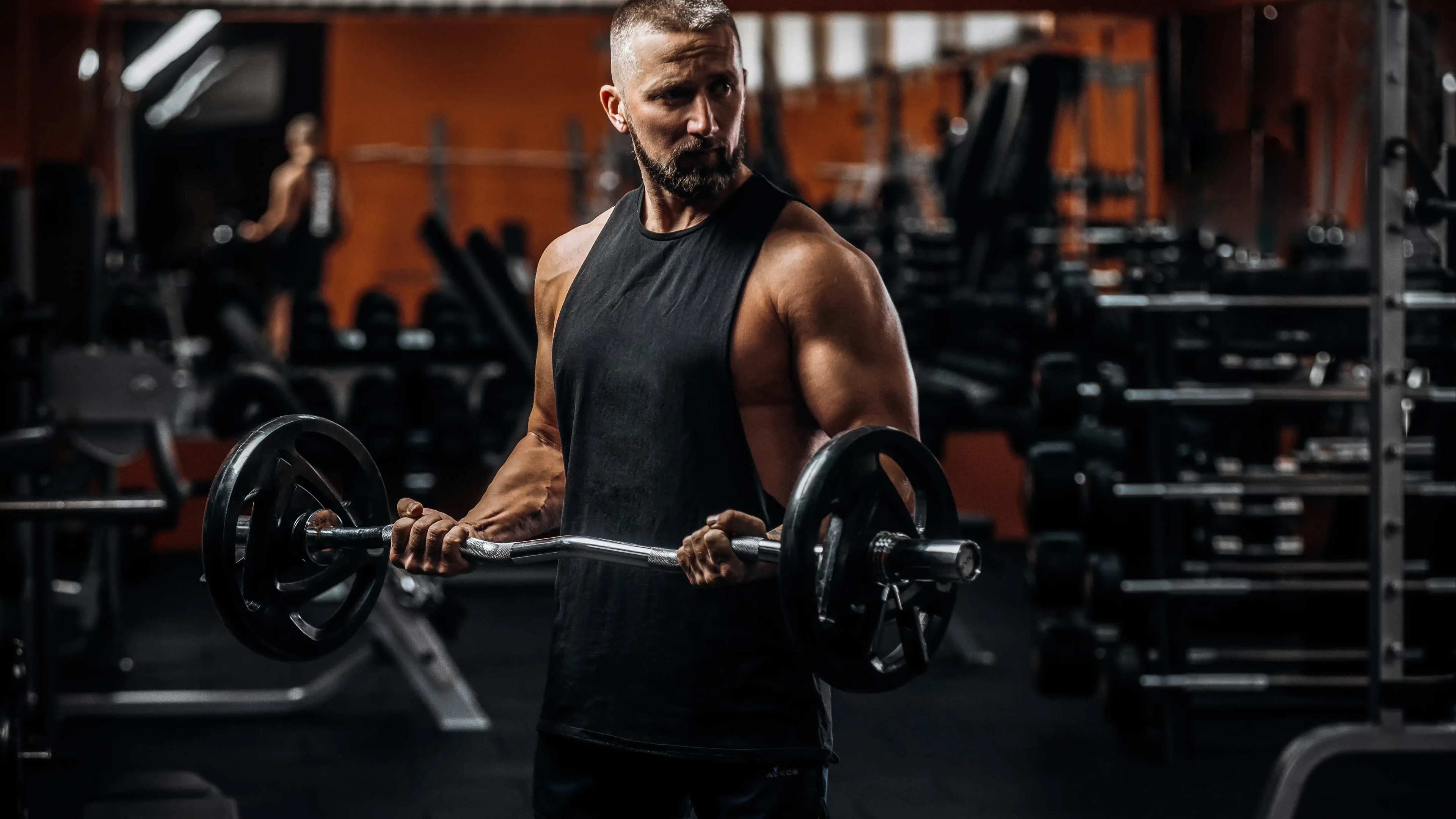Ein Mann macht Bizeps Curls mit SZ-Hantelstange
