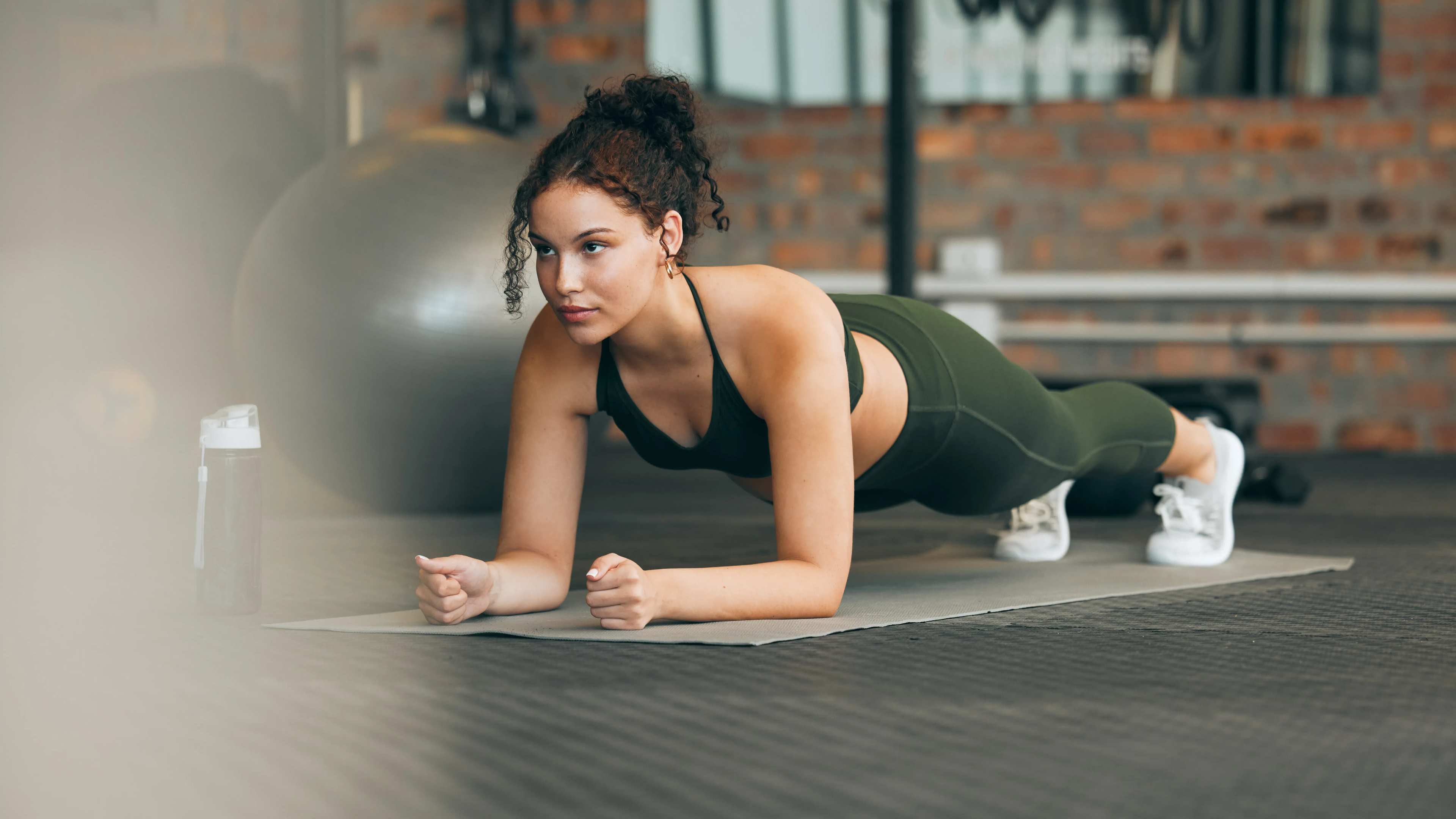 Eine Frau macht eine Plank im Fitnessstudio auf einer Matte