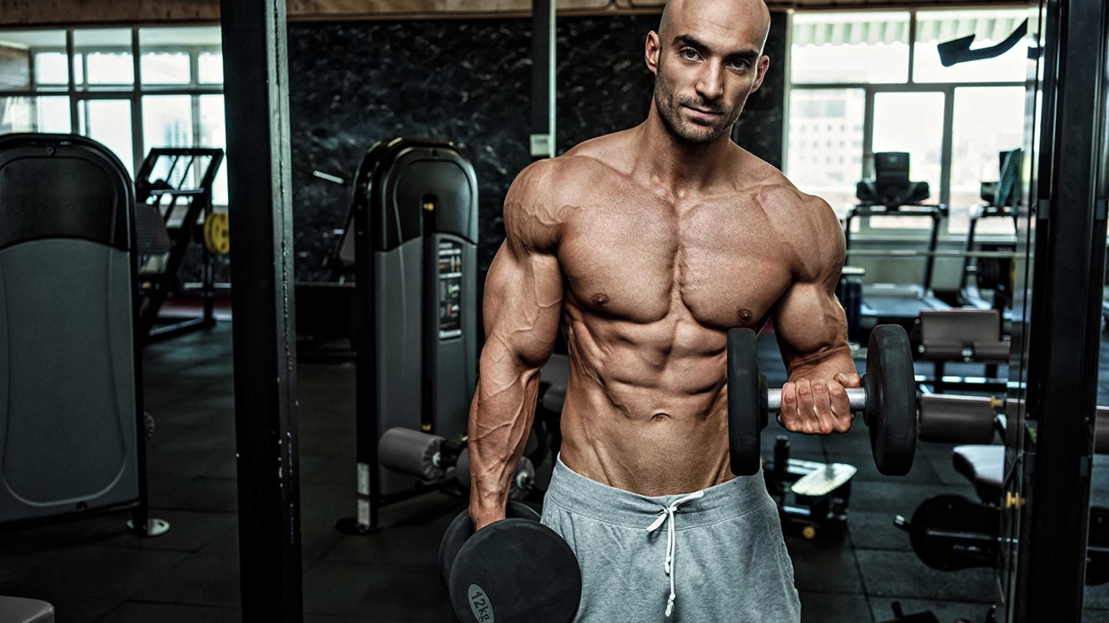 Ein oberkörperfreier Mann macht Bizeps Curls