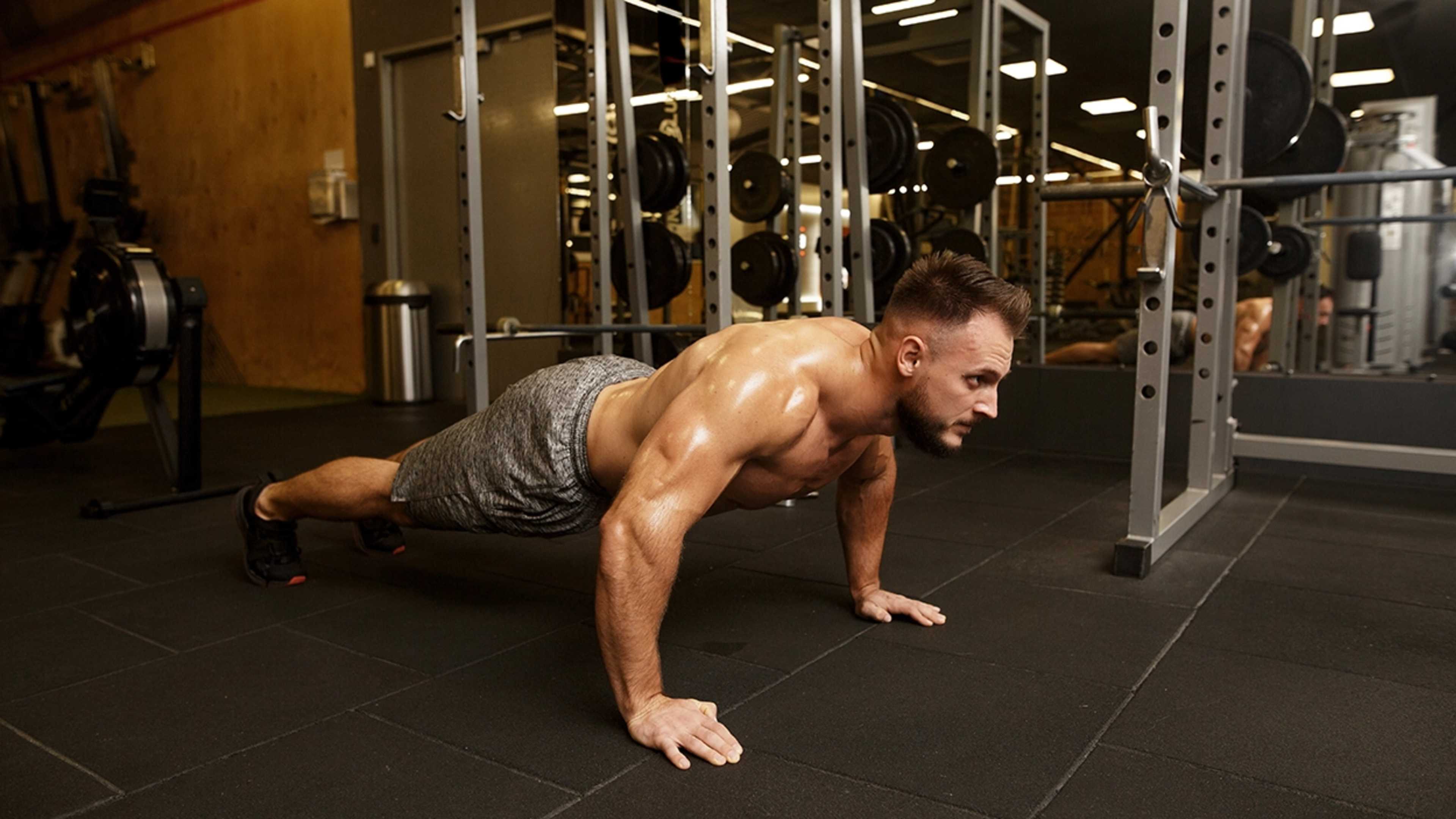Ein Mann macht Liegestütze im Fitnessstudio