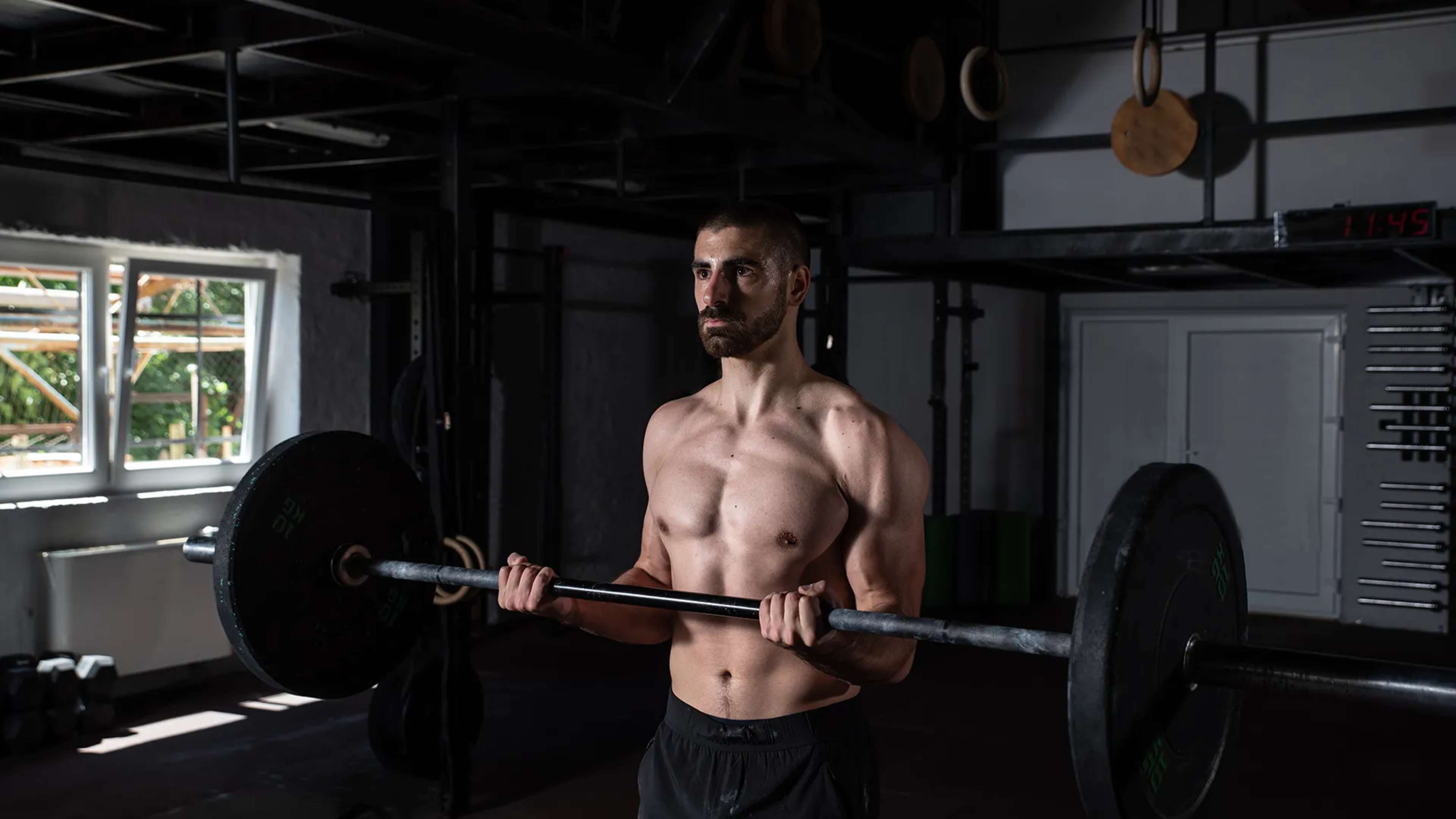 Ein Mann macht Bizeps Curls mit einer geraden Langhantel