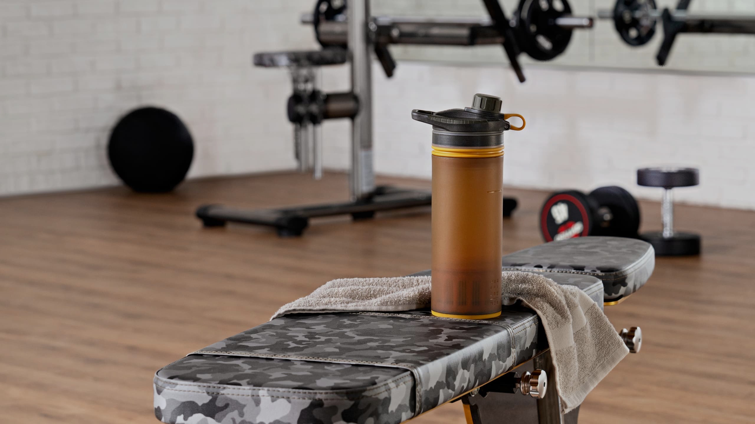 Trinkflasche und Handtuch auf einer Hantelbank im Gold's Gym Fitnessstudio