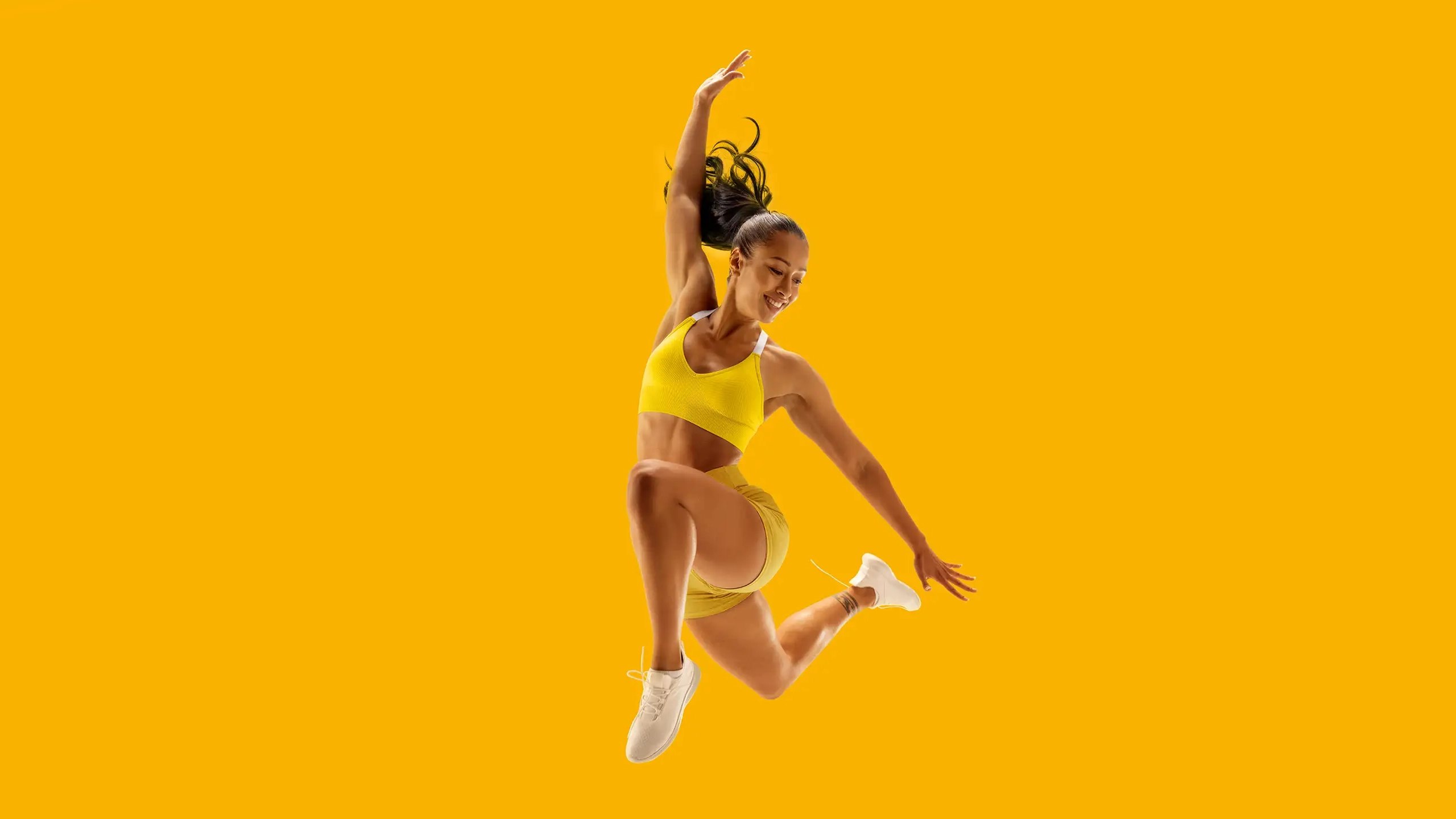 McFIT atleta che salta su sfondo giallo